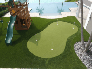 Sims & Greens | The Clearwater Lawn Reformation | Performance Engineering - Sims & Greens This project in Clearwater is a definitive example of an Engineered Landscape Replacement. We aren't just swapping grass for plastic; we are converting a high-maintenance liability into a high-performance asset. Most "turf guys" would just roll out a generic lawn-replacement product here. We treated this as a Topographical Reformation. We analyzed the runoff patterns toward the Clearwater coastal shelf and engineered a green that serves as both a functional practice facility and a structural drainage solution. Image Metadata: clearwater-fl-putting-green-lawn-replacement-1.png 1. Alt Text (Technical & Performance) "High-performance lawn replacement and putting green installation in Clearwater, FL, featuring multi-directional elite turf, a 4-layer aggregate drainage system, and custom-sculpted chipping fringes by Sims & Greens.