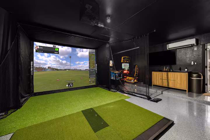 Professional home garage golf simulator installation in Florida featuring a custom-fit impact screen, high-quality hitting mat, and side-wall protection.