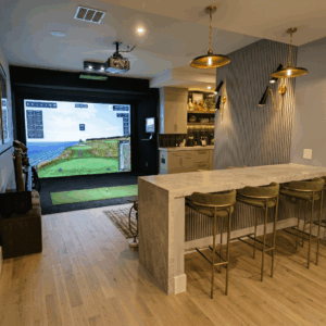 A luxury indoor golf simulator room A custom residential garage completely converted into a high-end indoor golf simulator studio in St. Petersburg, Florida, featuring an edge-to-edge impact screen, premium artificial turf flooring, and professional acoustic treatments. Clearwater, Florida, featuring a custom-built granite entertainment bar with seating, perfectly positioned behind the hitting area and impact screen for premium home entertaining.