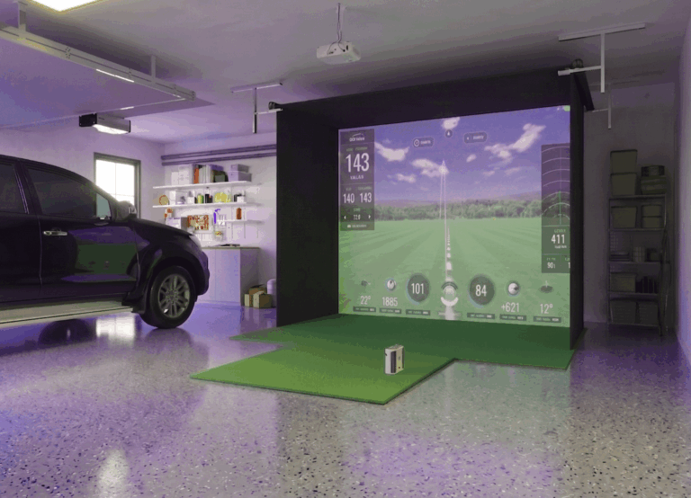 Car in a garage on a driving-simulation setup, with a large screen showing a landscape and dashboard readouts.