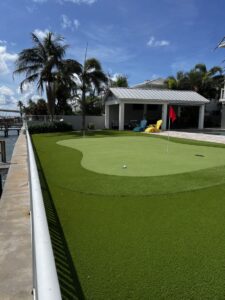 backyard-putting-green-319 1st Street West St Petersburg FL - Sims & Greens Professional backyard putting green in St. Petersburg, FL, featuring custom-engineered undulations, true-roll synthetic turf, and a precision-cut chipping fringe by Sims & Greens.
