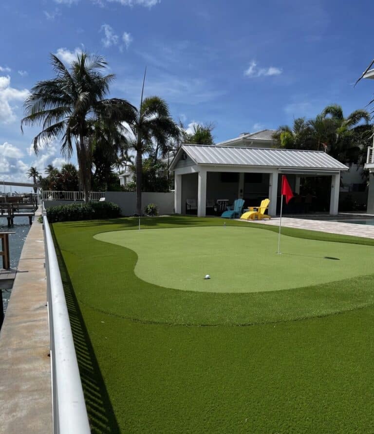 Professional backyard putting green in St. Petersburg, FL, featuring custom-engineered undulations, true-roll synthetic turf, and a precision-cut chipping fringe by Sims & Greens.