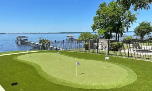 Custom artificial turf putting and chipping green on the Florida Gulf Coast, featuring tour-grade fringe and a waterfront view.